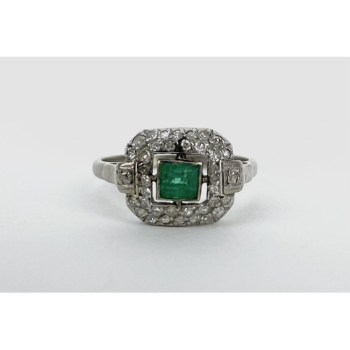 164 - An 18ct white gold and platinum ring set with a central emerald, 44mm x 3.5mm, with two bands of dia... 