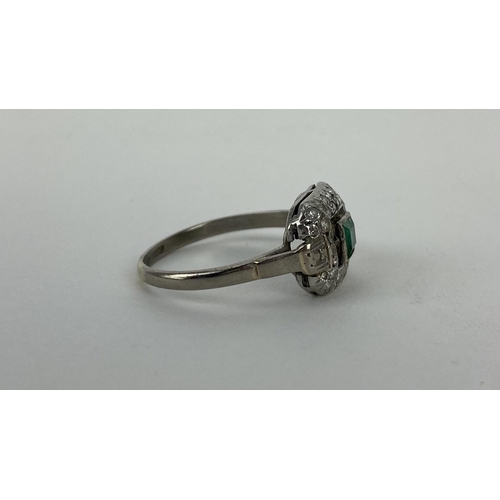 164 - An 18ct white gold and platinum ring set with a central emerald, 44mm x 3.5mm, with two bands of dia... 