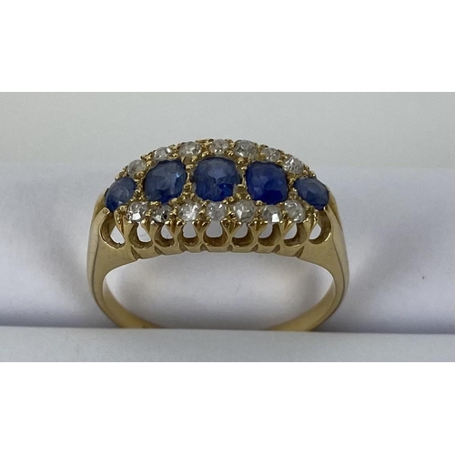 165 - An 18ct yellow gold ring set with five blue sapphires, largest 3.8mm x 3 mm, surrounded by bands of ... 