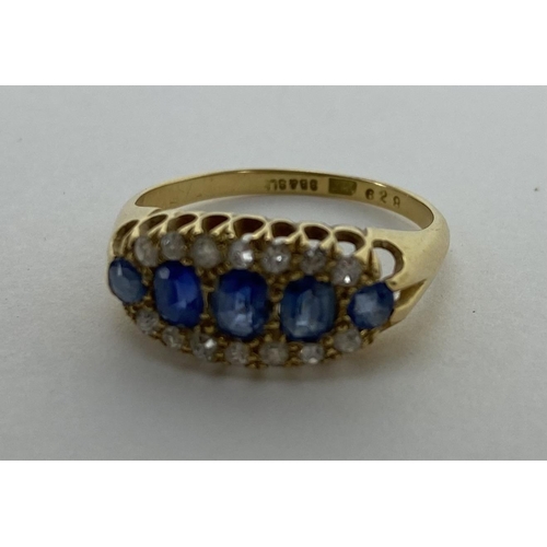 165 - An 18ct yellow gold ring set with five blue sapphires, largest 3.8mm x 3 mm, surrounded by bands of ... 