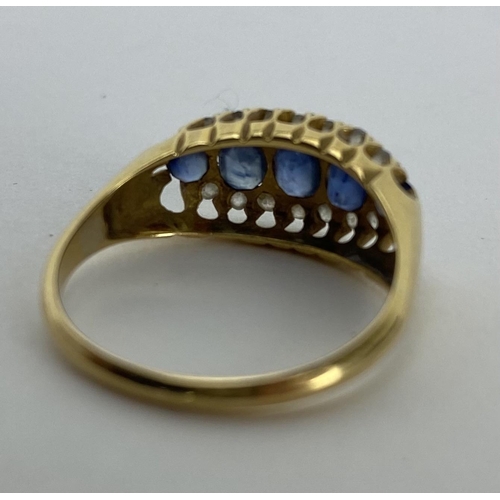 165 - An 18ct yellow gold ring set with five blue sapphires, largest 3.8mm x 3 mm, surrounded by bands of ... 