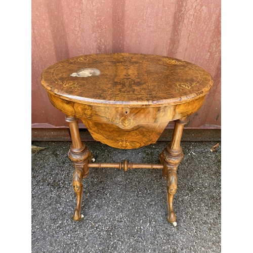 176 - A late Victorian figured walnut and marquetry oval work table, with a hinged lid, enclosing a compar... 