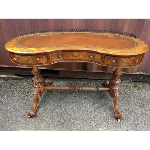 177 - A late Victorian figured walnut and marquetry kidney shaped desk, with a gilt metal gallery and brow... 