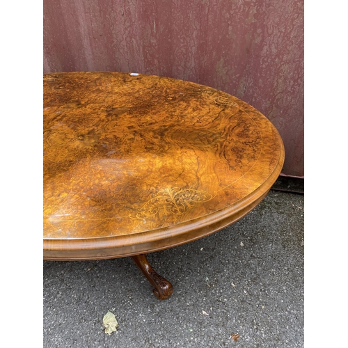 178 - A late Victorian figured walnut and marquetry loo table with an oval tip top, over a bulbous carved ... 