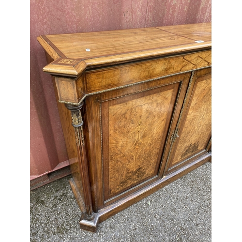 180 - A late Victorian mixed veneer and marquetry cabinet with gilt metal mounts, a pair of panelled doors... 