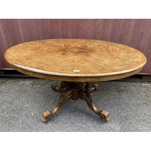 183 - A late Victorian figured walnut and marquetry loo table with an oval tip top, over four columns, on ... 