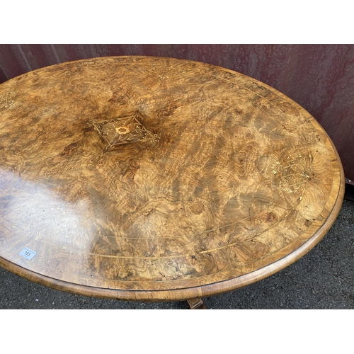 183 - A late Victorian figured walnut and marquetry loo table with an oval tip top, over four columns, on ... 