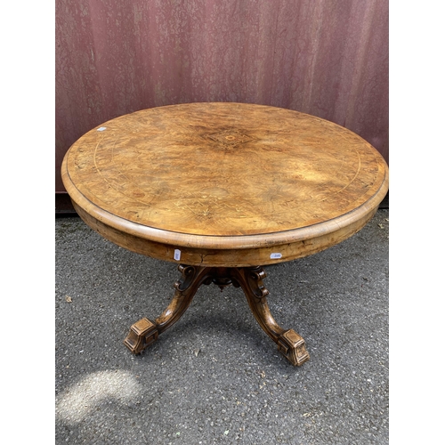 183 - A late Victorian figured walnut and marquetry loo table with an oval tip top, over four columns, on ... 