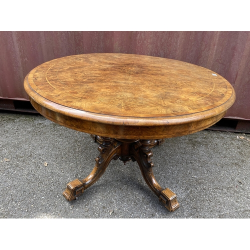 183 - A late Victorian figured walnut and marquetry loo table with an oval tip top, over four columns, on ... 