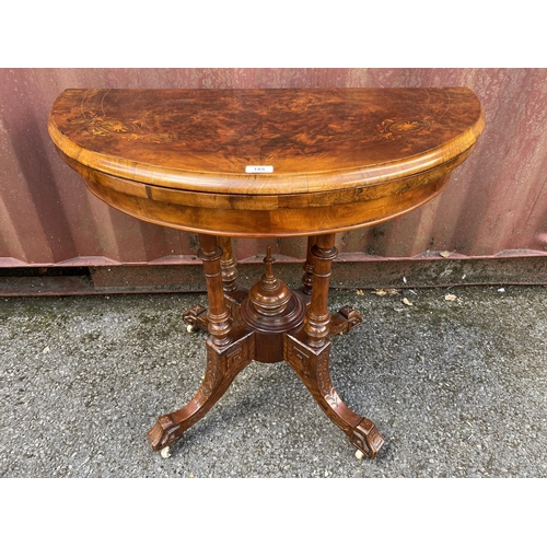 185 - A late Victorian figured walnut and marquetry demi-lune card table, over turned columns, on splayed ... 