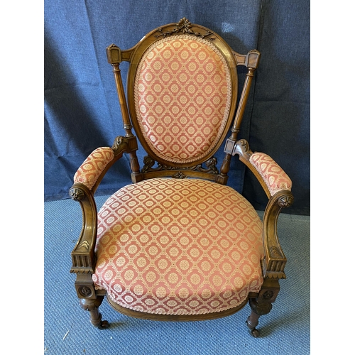 190 - A late Victorian walnut framed open arm chair with an oval back and overstuffed seat, with a pink an... 