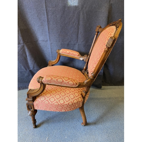 190 - A late Victorian walnut framed open arm chair with an oval back and overstuffed seat, with a pink an... 