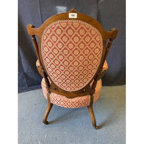 190 - A late Victorian walnut framed open arm chair with an oval back and overstuffed seat, with a pink an... 