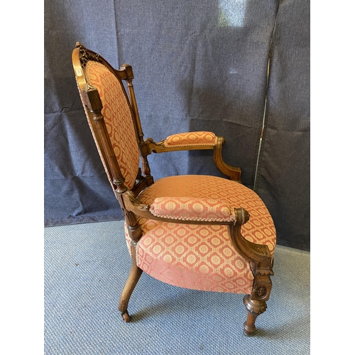 190 - A late Victorian walnut framed open arm chair with an oval back and overstuffed seat, with a pink an... 