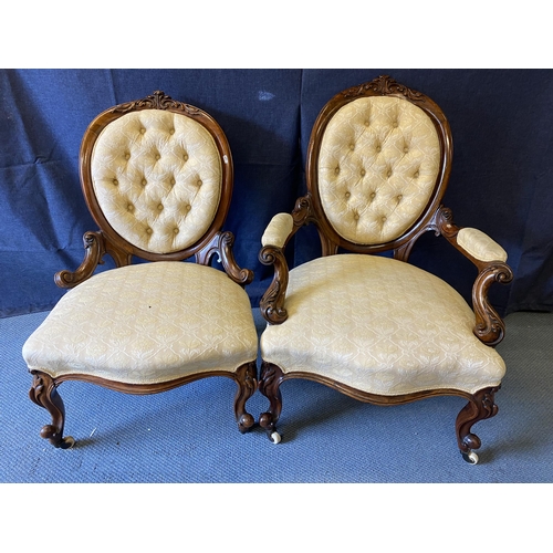 191 - A pair of mid Victorian walnut framed ladies and gentleman's chairs, each with carved crests, oval b... 