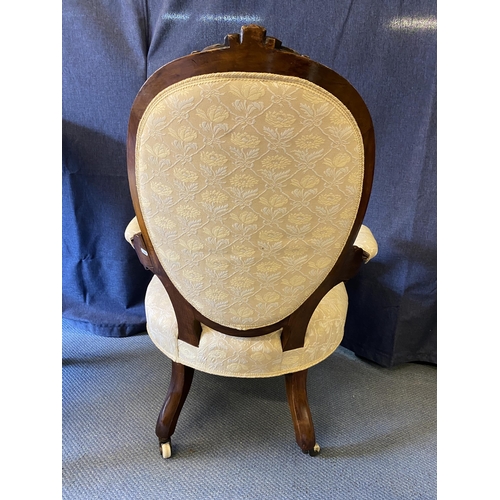 191 - A pair of mid Victorian walnut framed ladies and gentleman's chairs, each with carved crests, oval b... 