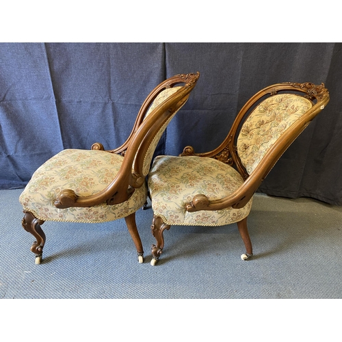 192 - A pair of late Victorian carved walnut framed chairs with oval button backs and serpentine front sea... 