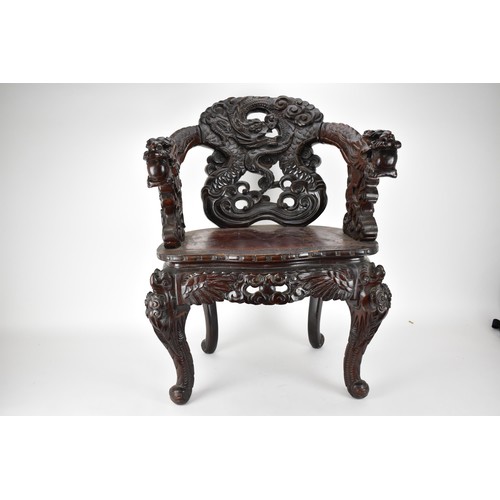 113A - A Chinese late 19th century carved wooden chair with a central panel of a dragon and clouds, the arm... 