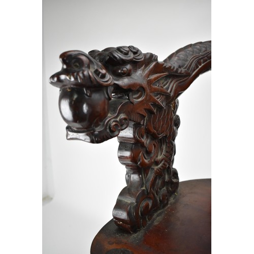 113A - A Chinese late 19th century carved wooden chair with a central panel of a dragon and clouds, the arm... 