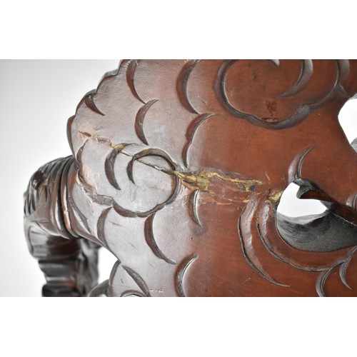 113A - A Chinese late 19th century carved wooden chair with a central panel of a dragon and clouds, the arm... 