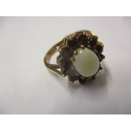 134 - A 9ct gold opal and garnet ring size J, total weight 2.9g Location: Cab