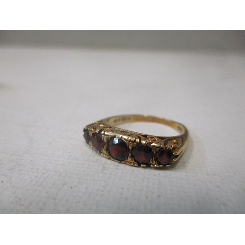 158 - A 9ct gold ring set with five graduated garnets, circa 1970, and a 9ct gold and black onyx plaque ri... 