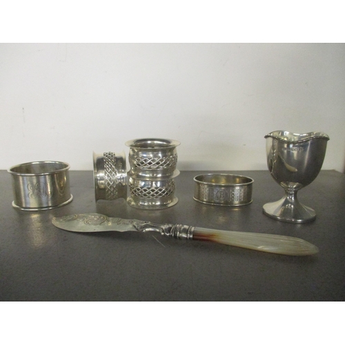 182 - A group of silver items to include a set of three Edwardian napkin rings, Chester 1903, a Victorian ... 