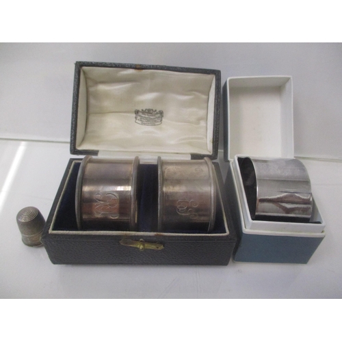 5 - A pair of silver napkin rings, boxed, a napkin ring box and a thimble, 65g
Location: CAB