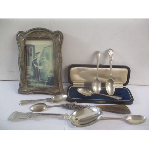 63 - Mixed silver to include a picture frame, together with a white metal serving spoon. Weight excluding... 