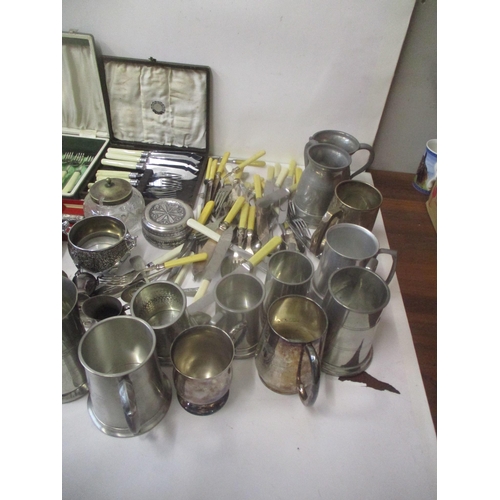 111 - Silver plate and metalware to include tankards, sets of fish knives and forks, a cake slice, a ladle... 