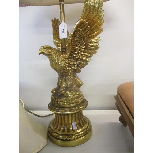 108 - A brass coloured table lamp in the form of an eagle with outstretched wings, perched on a rocky base... 