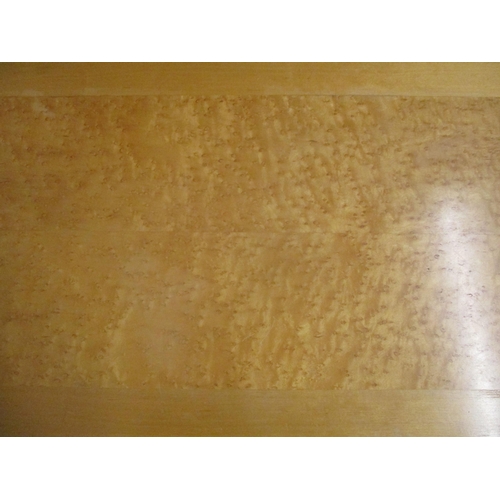 109 - A contemporary light wood coffee table with bird's eye maple veneered top, standing on four slightly... 