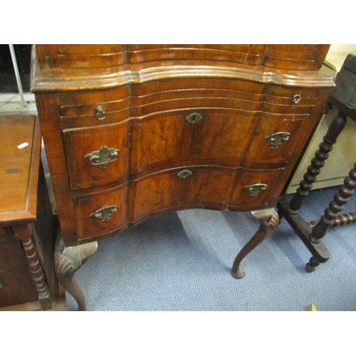 122 - A Queen Anne style figured walnut chest on stand having a stepped cornice above six drawers with a b... 
