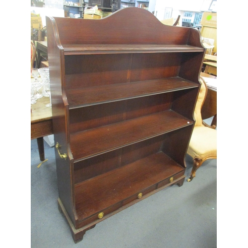 71 - A reproduction mahogany four tier open bookcase with three drawers below and twin carrying handles, ... 