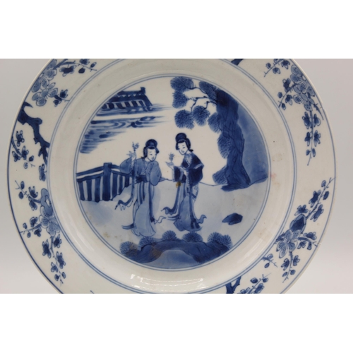 6 - A Chinese Kangxi blue and white plate decorated to the centre with two ladies each holding a sprig o... 