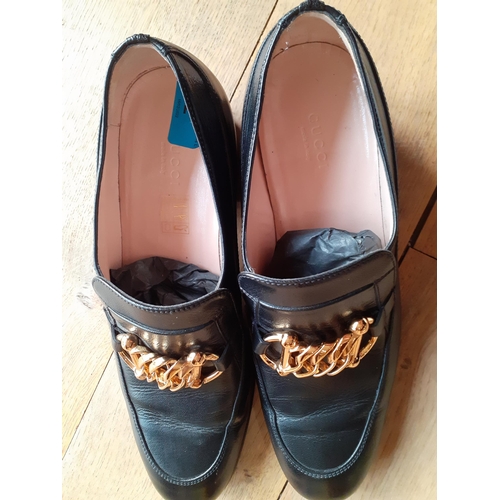 2 - Gucci-A pair of Unisex Ice Lolly black leather loafers, having gold tone horse-bit style chain hardw... 