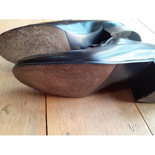 2 - Gucci-A pair of Unisex Ice Lolly black leather loafers, having gold tone horse-bit style chain hardw... 