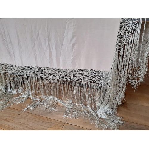 4 - An early 20th Century cream silk tasselled shawl having a hand-crotchet triple band surround with ex... 