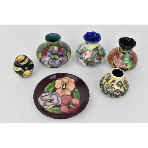 168 - A small collection of Moorcroft ceramics, to include a squat vase in the 'Clematis' pattern on green... 