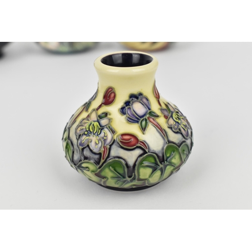 168 - A small collection of Moorcroft ceramics, to include a squat vase in the 'Clematis' pattern on green... 