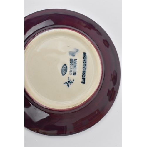 168 - A small collection of Moorcroft ceramics, to include a squat vase in the 'Clematis' pattern on green... 