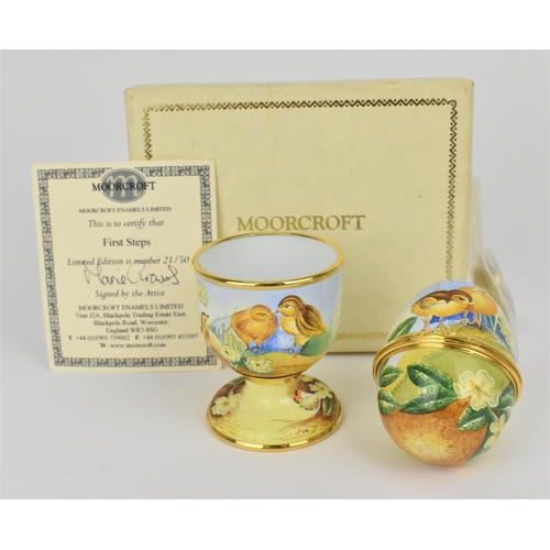 134 - A limited edition Moorcroft Enamels Ltd 'First Steps' egg cup and hinged egg painted by Marie Graves... 