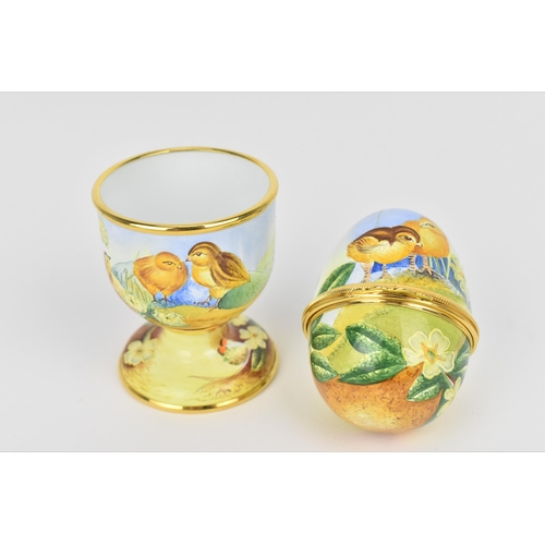 134 - A limited edition Moorcroft Enamels Ltd 'First Steps' egg cup and hinged egg painted by Marie Graves... 