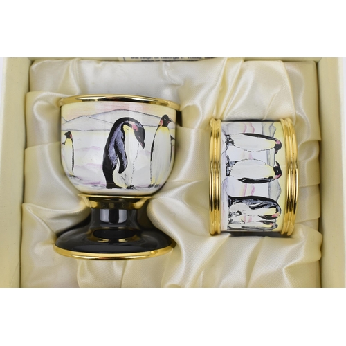 139 - A Moorcroft Enamels Ltd Penguin family pattern egg cup and napkin ring set, designed by Amanda Rose,... 