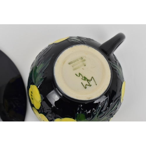 163 - A Moorcroft pottery 'Buttercup' pattern cup and saucer designed by Sally Tuffin, together with a mat... 