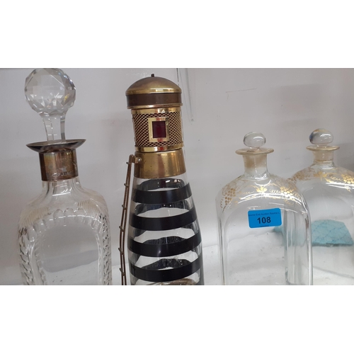 108 - Two Victorian clear glass decanters with gilt ornament, a decanter with a silver collar, another fas... 