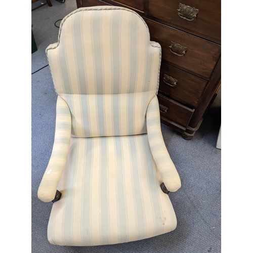 187 - A Victorian armchair upholstered in a striped fabric with a long seat, curved arms and ring turned l... 