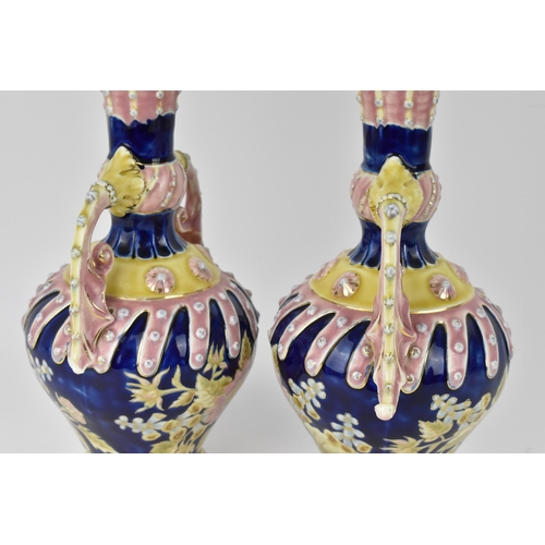 107 - A pair of late 19th century Zsolnay Pecs glazed ceramic pair of ewers, in the Turkish style with twi... 