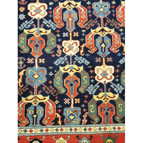 159 - A Turkish rug with repeated geometric motifs in pastel blue, red, yellow and green, 310cm x 210cm