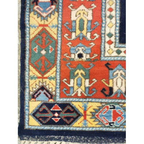 159 - A Turkish rug with repeated geometric motifs in pastel blue, red, yellow and green, 310cm x 210cm